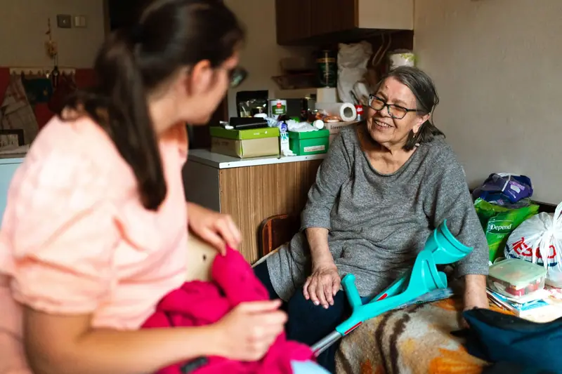 A caregiver helping an older woman at home